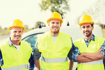 Image showing group of smiling builders in hardhats outdoors