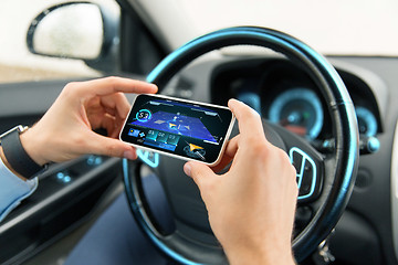 Image showing hands with navigator on smartphone in car