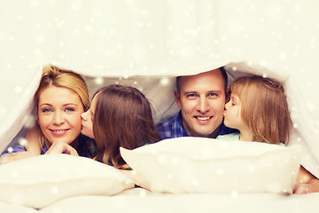 Image showing happy family with two kids under blanket at home