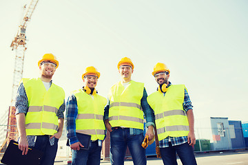 Image showing group of smiling builders with tablet pc outdoors