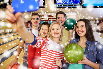 Image showing happy friends with smartphone in bowling club