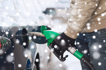 Image showing close up of man with fuel hose nozzle tanking car