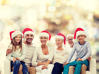 Image showing happy family in santa helper hats sitting on couch