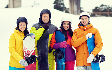 Image showing happy friends in helmets with snowboards