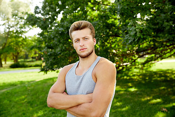 Image showing sporty young man with crossed arms at summer park