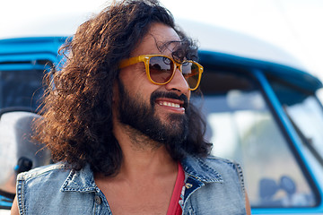 Image showing smiling young hippie man over minivan car