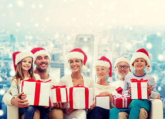 Image showing happy family in santa helper hats with gift boxes