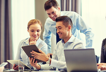 Image showing smiling business people with tablet pc in office