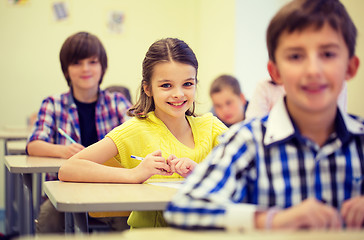 Image showing group of school kids with notebooks in classroom