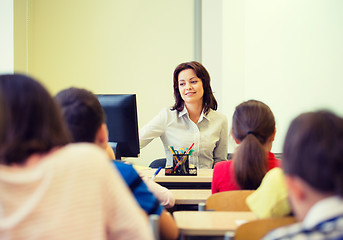 Image showing group of school kids raising hands in classroom