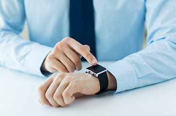 Image showing close up of male hands setting smart watch