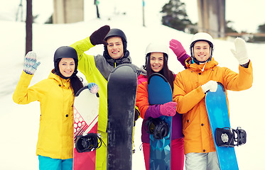 Image showing happy friends in helmets with snowboards