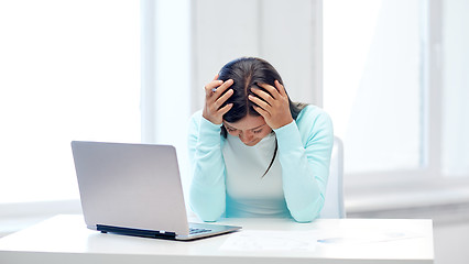 Image showing businesswoman with laptop and papers in office