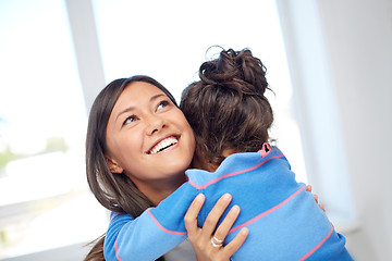 Image showing happy mother and daughter hugging at home