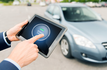 Image showing close up of hands with car starter on tablet pc