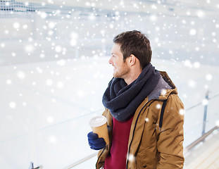 Image showing happy young man with coffee cup on skating rink