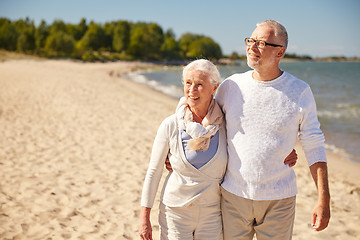 Image showing happy senior couple walking along summer beach