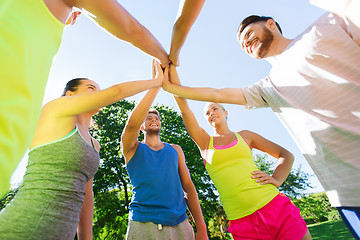 Image showing group of happy friends making high five outdoors