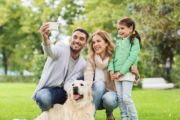 Image showing happy family with dog taking selfie by smartphone