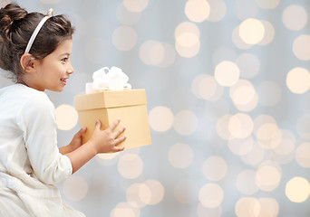 Image showing happy little girl with present over lights