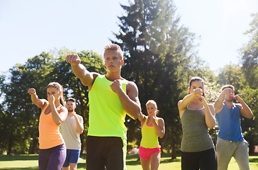 Image showing group of friends or sportsmen exercising outdoors