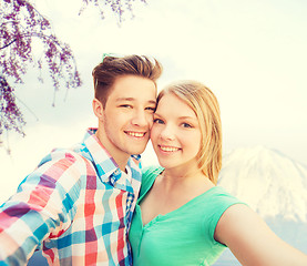 Image showing smiling couple with smartphone in city