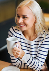 Image showing happy young woman drinking tea or coffee