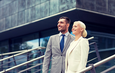 Image showing smiling businessmen standing over office building