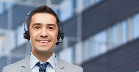 Image showing happy businessman in headset over business center