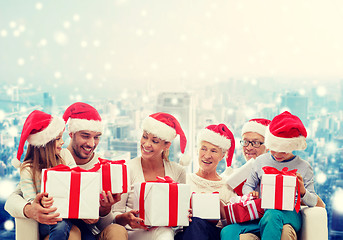 Image showing happy family in santa helper hats with gift boxes