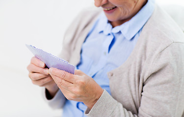 Image showing close up of happy senior woman playing cards