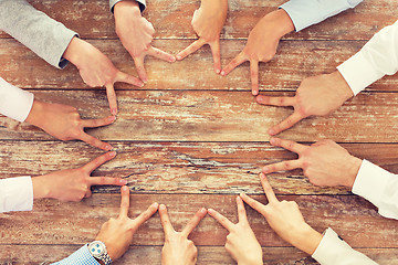 Image showing close up of business team showing victory gesture