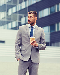 Image showing young serious businessman with paper cup outdoors