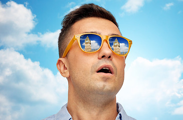 Image showing face of man in sunglasses looking at big ben tower