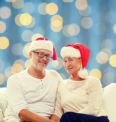 Image showing happy senior couple in santa helper hats