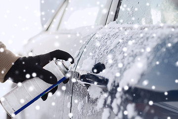 Image showing closeup of man hand with lock door de-icer