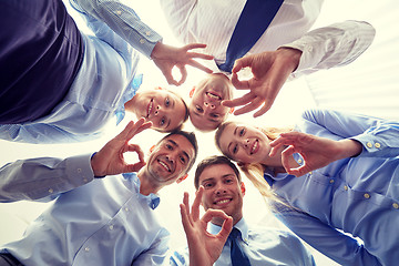 Image showing smiling group of businesspeople standing in circle