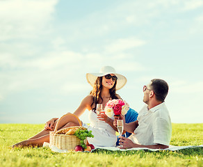 Image showing smiling couple drinking champagne on picnic