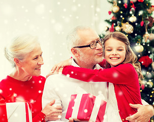 Image showing smiling family with gifts at home