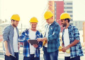 Image showing group of smiling builders with tablet pc outdoors