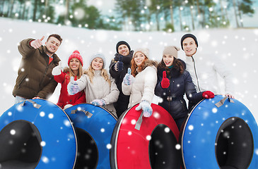 Image showing group of smiling friends with snow tubes