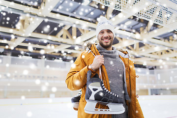 Image showing happy young man with ice-skates on skating rink