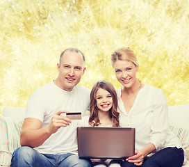 Image showing happy family with laptop computer and credit card