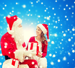 Image showing smiling little girl with santa claus and gifts