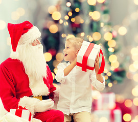 Image showing smiling little boy with santa claus and gifts