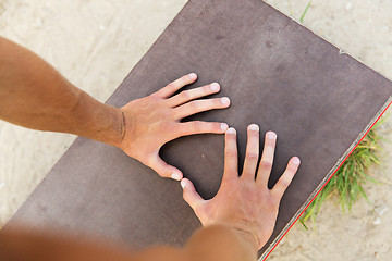 Image showing close up of man hands exercising on bench outdoors