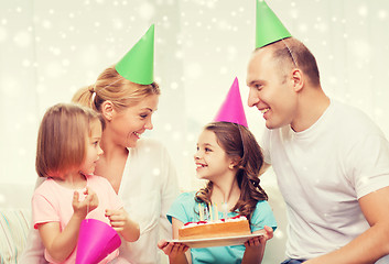 Image showing happy family with two kids in party hats at home