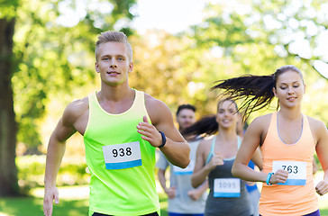 Image showing happ young sportsmen racing wit badge numbers