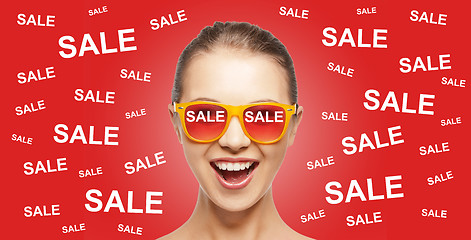 Image showing happy teenage girl in shades with sale signs