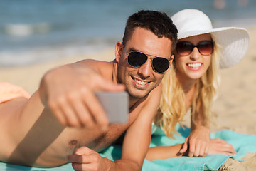 Image showing happy couple in swimwear walking on summer beach